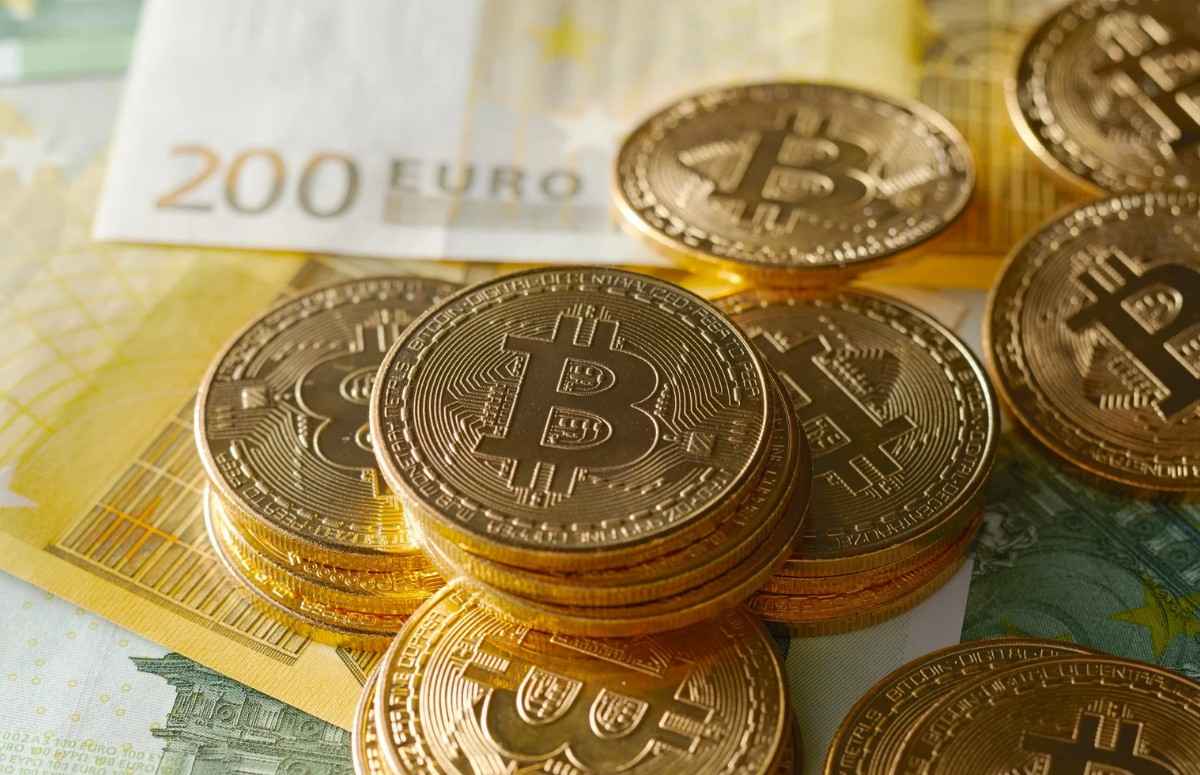 Golden Bitcoin coins placed on Euro currency notes representing digital investment